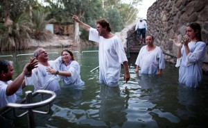 Christian Pilgrims participating in a group baptismal ritual in the river Jordan